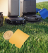 Plateau de jeu Cornhole Bean Bag jaune et bleu posé sur l'herbe près des fondations de la maison. Équipement de jeu sur gazon présenté, prêt pour les jeux récréatifs en plein air.