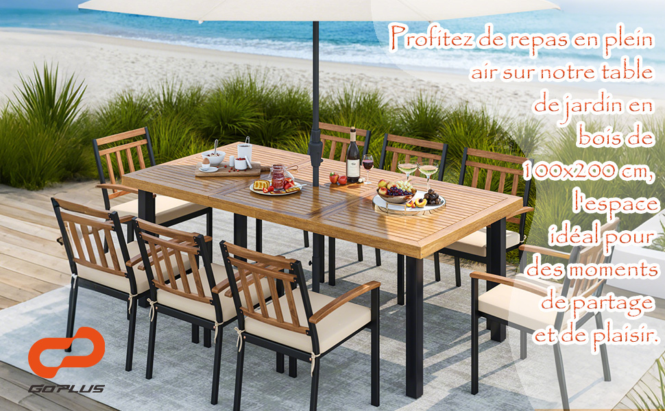 avec table et chaises en bois sur la terrasse de la plage. La table mesure 193 x 200 cm. Monture en métal noir, trou pour parasol. Fond de vue sur l'océan.