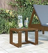 Table à manger d'extérieur en bois avec coussin de siège gris-bleu sur une terrasse blanche à côté de plantes de jardin et d'un mur contemporain.