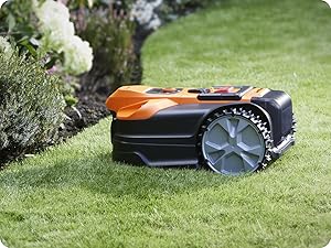 Tondeuse à gazon robotisée fonctionnant sur de l'herbe verte, illustrée sous plusieurs angles avec des roues et un mécanisme de coupe visibles.