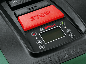 Gros plan d'un panneau de commande numérique ou d'une interface avec un bouton STOP rouge et un écran LCD avec boutons de navigation.