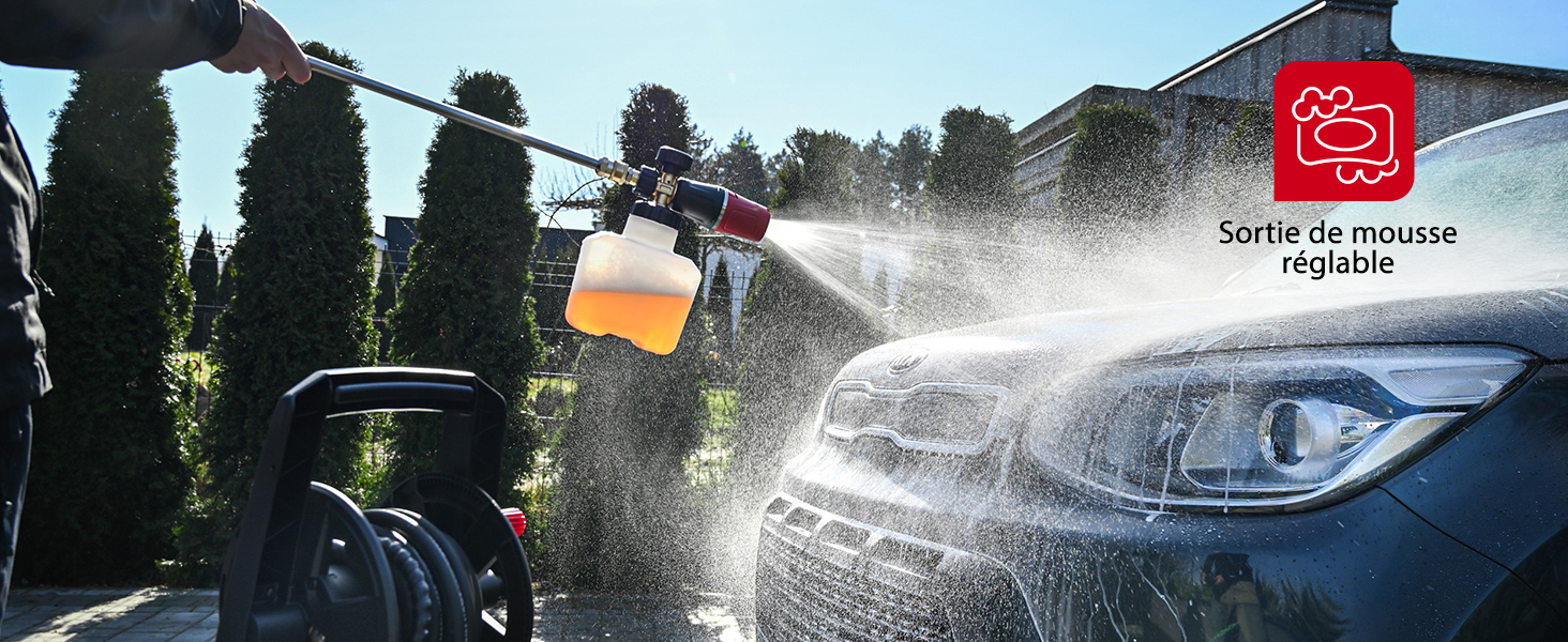 en cours d'utilisation, pulvérisant de la mousse sur le capot d'une voiture. L'appareil dispose d'une sortie de mousse réglable. De l'eau pulvérisée et de la mousse sont visibles sur l'extérieur bleu du véhicule