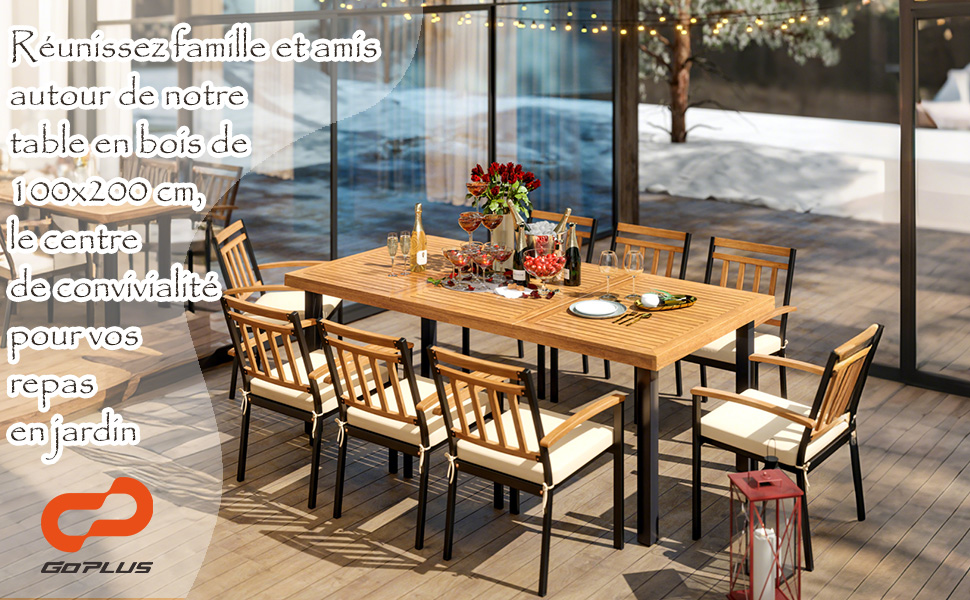 avec table et chaises en bois sur le patio. La table mesure 100 x 200 cm. Sièges rembourrés, armatures métalliques. Guirlandes lumineuses et scène enneigée visibles à travers les parois vitrées