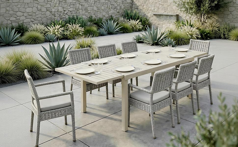 Le texte se lit comme suit : « Image 1 ». Ensemble de mobilier de patio extérieur comprenant plusieurs chaises grises modernes et une table à manger disposées dans un cadre paysager avec des plantes d'agave décoratives.