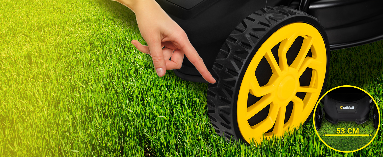 Gros plan d'un couvre-roue ou d'un enjoliveur jaune vif sur une herbe verte éclatante, avec une main visible tendant la main vers la roue.