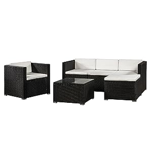 comprenant un canapé en osier noir, un fauteuil et une table basse avec des coussins blancs, idéal pour le jardin ou la terrasse.