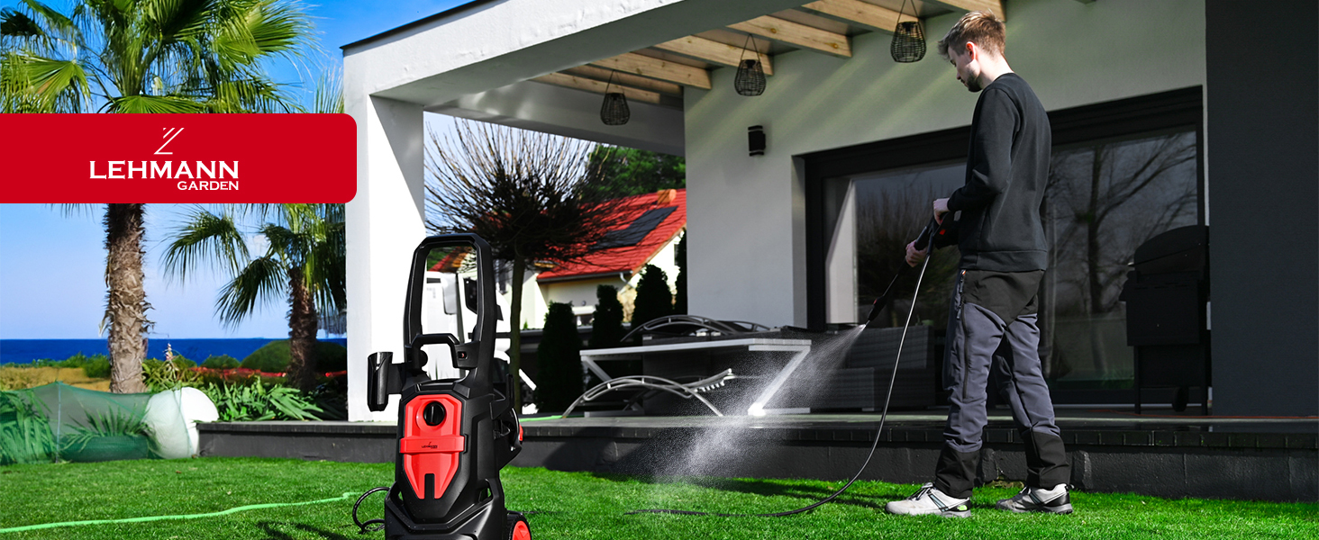 utilisé sur une terrasse. Une personne vêtue de noir fait fonctionner une machine à laver rouge et noire et pulvérise de l'eau sur une surface carrelée près de la maison avec des palmiers visibles.