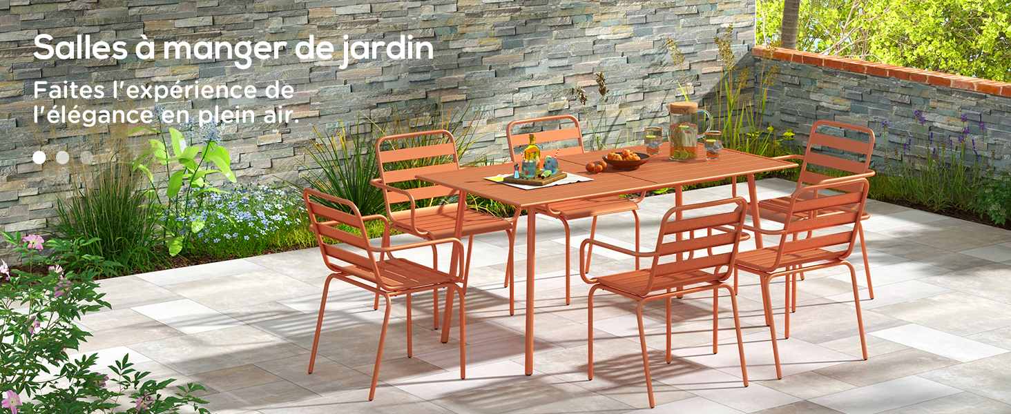 avec table et chaises en métal orange. Situé sur un patio en pierre contre un mur de pierre. Le texte mentionne une expérience culinaire dans le jardin.