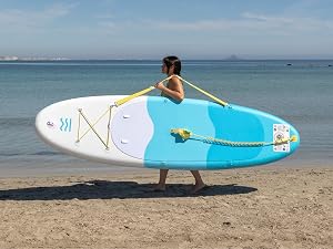 Séquence montrant une planche à pagaie turquoise et blanche sur une plage, montrant diverses positions et techniques de manipulation près de l'eau de mer.