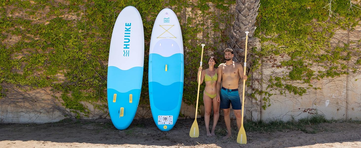 Vues multiples de planches à pagaie ou de planches de surf bleu clair transportées et utilisées près d'une plage ou d'une zone côtière. Les planches semblent gonflables avec des couleurs distinctives bleu clair et bleu foncé.