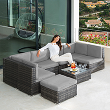 comprenant un canapé sectionnel gris et une table basse, avec une personne se relaxant et dégustant des rafraîchissements
