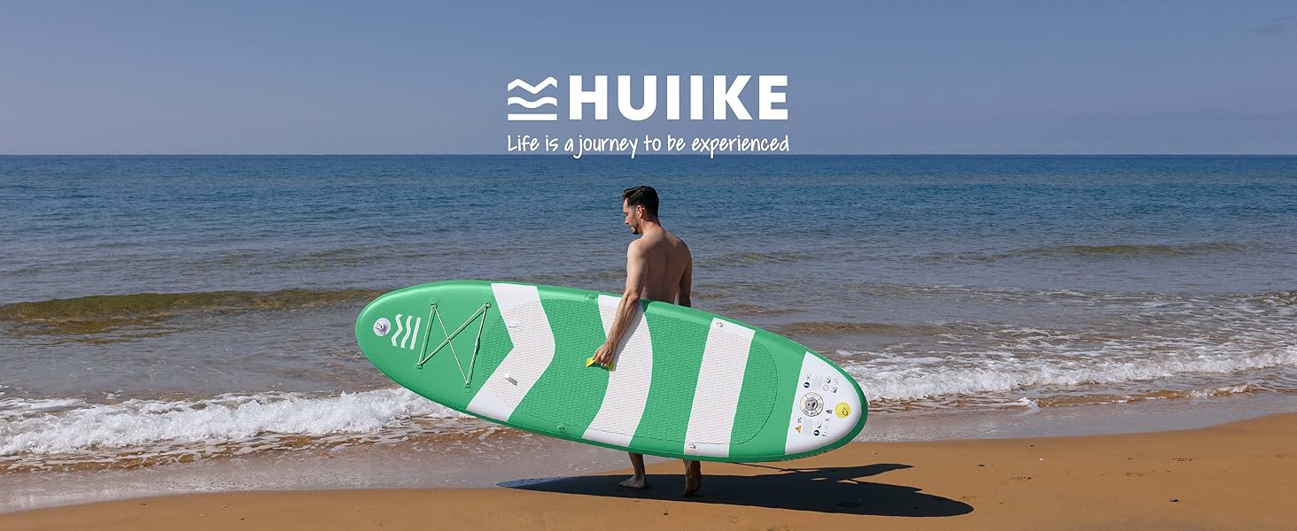 Planche de surf rayée verte et blanche posée sur une plage de sable avec les vagues de l'océan en arrière-plan