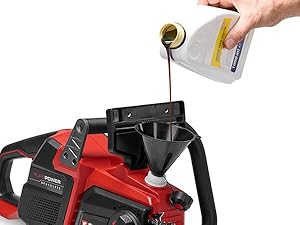 Versez à la main de l'huile liquide de couleur ambrée provenant d'un contenant transparent sur une machine-outil motorisée rouge et noire, pour démontrer l'application de maintenance ou de lubrification.