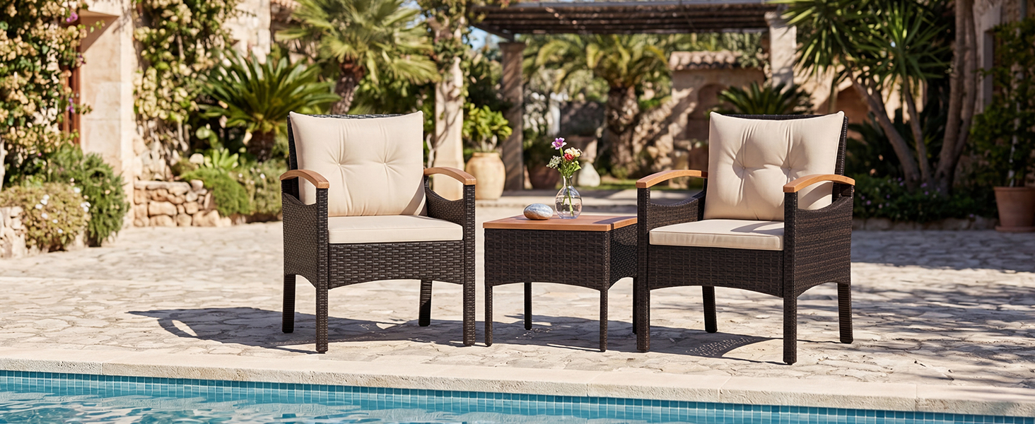 Ensemble de mobilier d'extérieur : deux chaises longues en bois foncé avec coussins placés sur un patio donnant sur une piscine bleue entourée d'un jardin paysager.