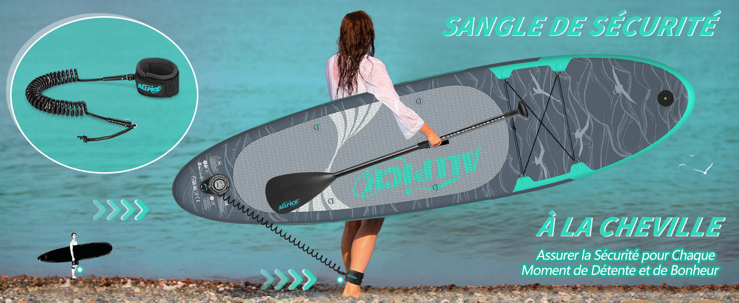 une femme tenant une planche à pagaie sur une plage.