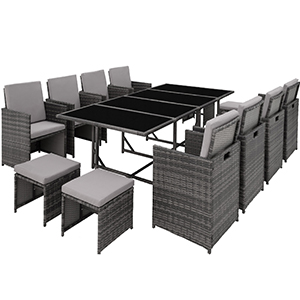 Grand ensemble de salle à manger d'extérieur avec des chaises en osier gris et une table en verre noir. L'ensemble comprend plusieurs chaises et semble extensible