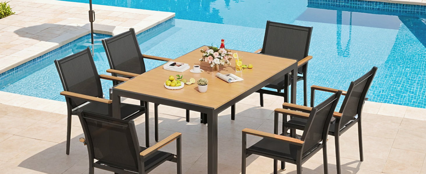 Le texte se lit comme suit : « Image 3 ». Ensemble de salle à manger pour terrasse extérieure avec table en bois et six chaises en maille noire disposées au bord de la piscine.