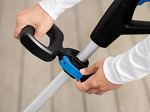 Démonstration de l'utilisation d'un appareil portable, montrant un outil bleu et noir manipulé sur un fond de tapis de couleur claire.