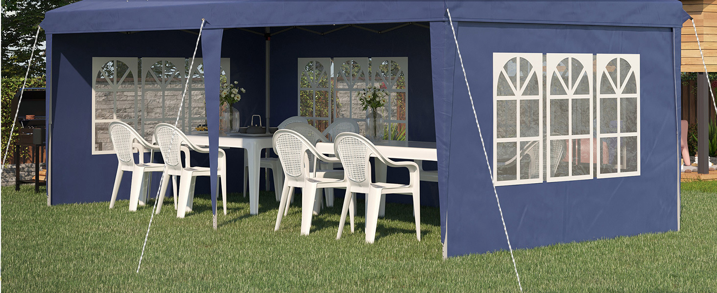 avec fenêtres et côtés blancs. Contient des chaises et une table en plastique blanc. Installé sur l'herbe, offrant un abri pour le coin salon extérieur.