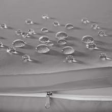 Des gouttelettes d'eau perlées sur une surface grise, démontrant des propriétés hydrofuges ou hydrophobes.