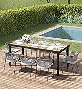 Salle à manger extérieure moderne avec table rectangulaire noire et chaises en maille sur une terrasse en bois à côté de la piscine et des haies vertes.