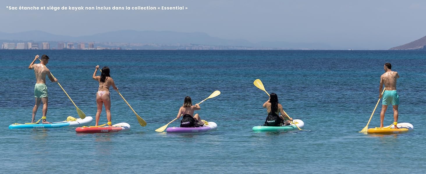 Groupe de personnes faisant du paddleboard sur les eaux bleues calmes de l'océan, debout sur des planches avec des pagaies.