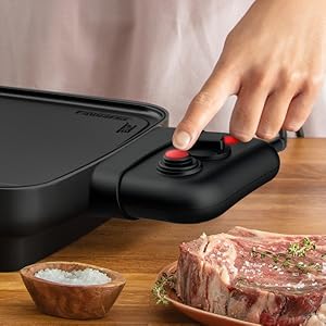 Plans rapprochés de la préparation des aliments montrant des mains travaillant avec des moules de cuisson foncés et des ingrédients crus dans une cuisine.