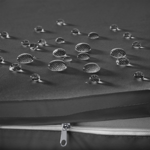 Des gouttelettes d'eau de différentes tailles sur une surface foncée, avec une fermeture éclair visible en bas, suggérant un produit imperméable ou résistant à l'eau