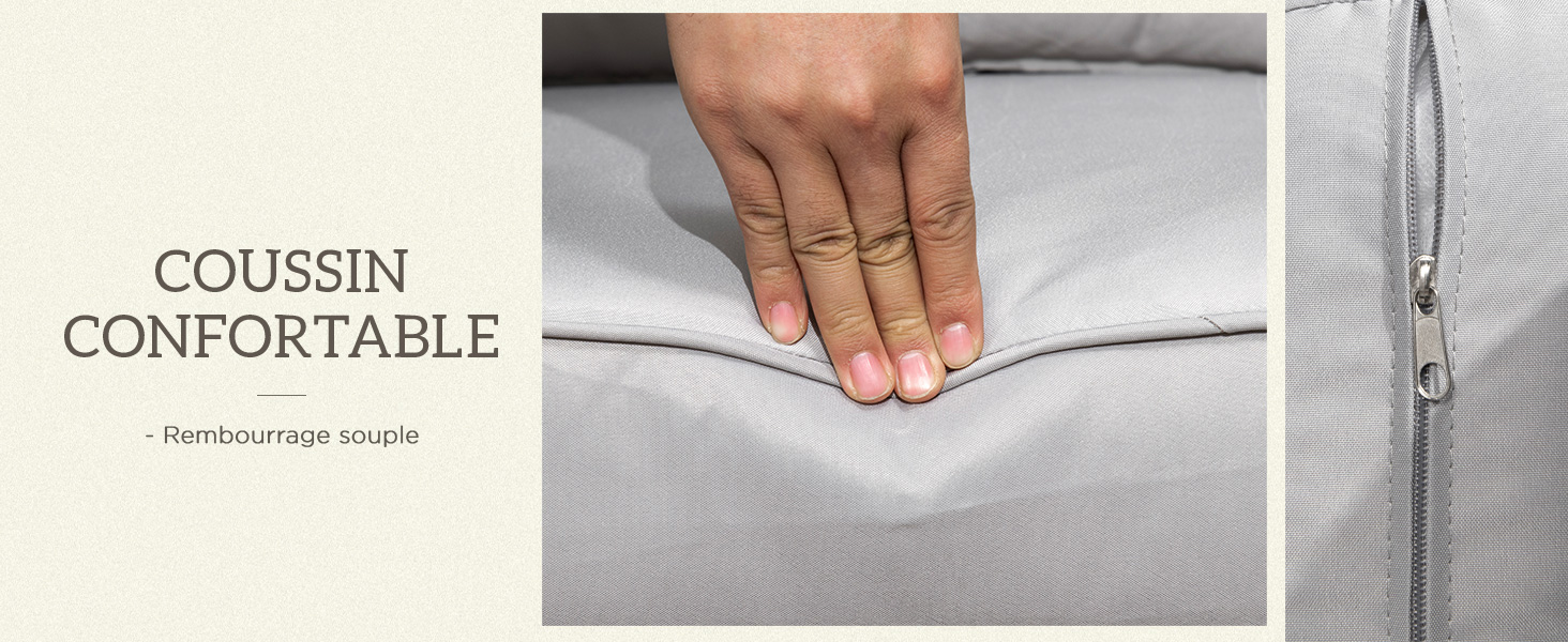 Gros plan d'une main appuyant sur une surface en tissu gris clair, démontrant la texture d'un coussin ou d'un oreiller confortable
