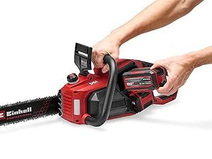 Tronçonneuse électrique rouge et noire tenue par deux mains, dotée d'une prise en main ergonomique et de commandes de déclenchement. Conception compacte sans fil avec boîtier moteur visible et chaîne de coupe.