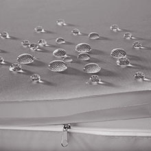 Plusieurs gouttelettes d'eau de différentes tailles sur une surface grise, avec une goutte plus grosse au centre de l'image