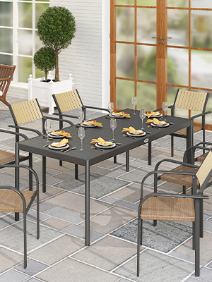 avec table rectangulaire grise et six chaises bronzées. La table est garnie d'assiettes jaunes et de verres à vin. Plantes topiaires en pot