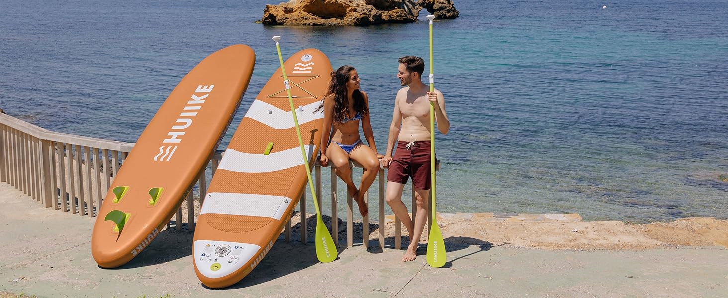 un couple assis sur une plage avec des pagaies