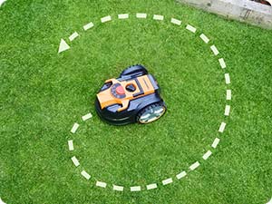 Tondeuse à gazon robotique sur gazon vert avec indication de trajectoire circulaire en pointillés indiquant son schéma de mouvement.