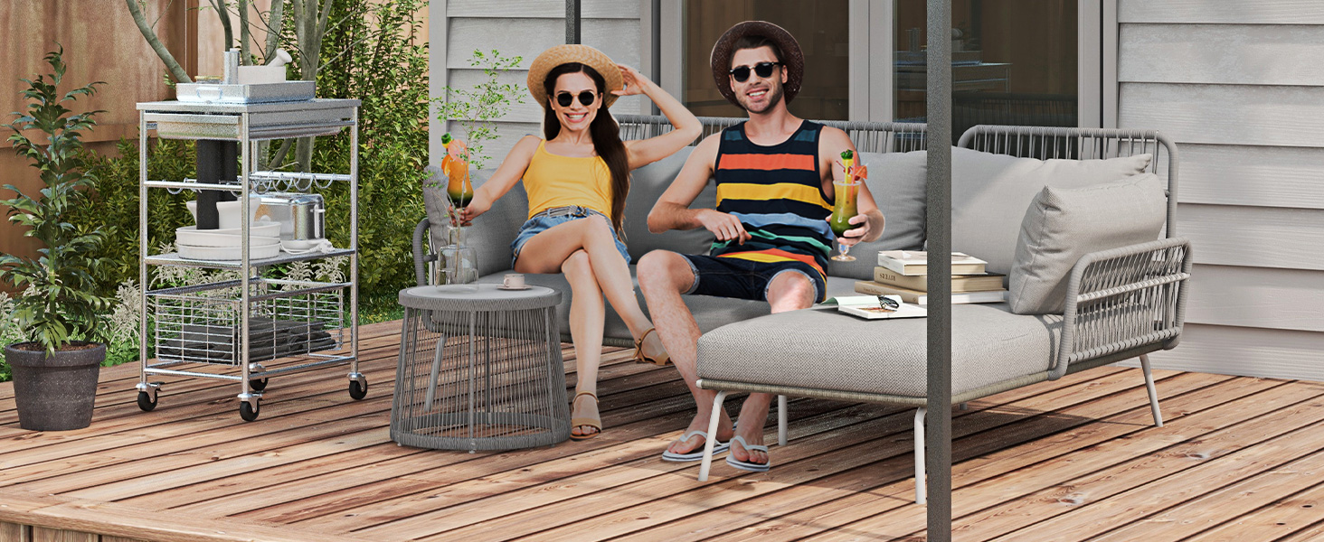 avec sièges rembourrés gris et table d'appoint en osier sur terrasse en bois avec support décoratif pour plantes