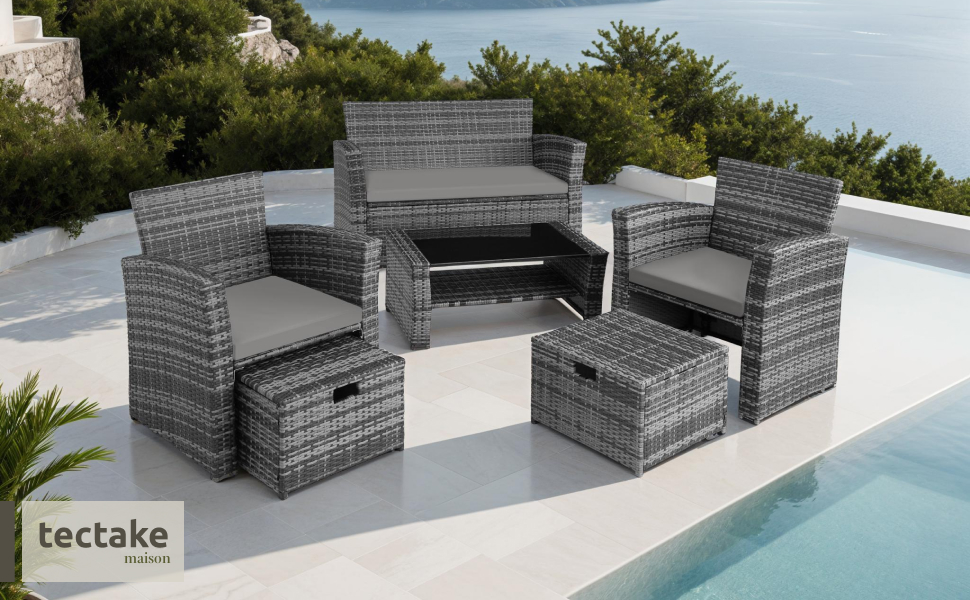 Ensemble de meubles d'extérieur en osier gris comprenant un canapé, des chaises et une table disposés sur une terrasse blanche près de la piscine.